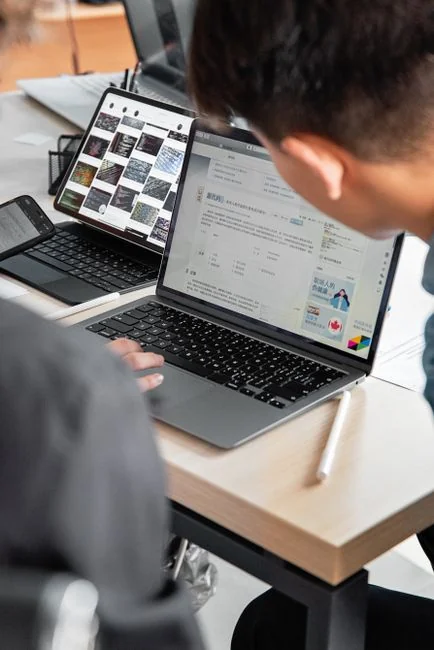 An adult uses a credit card for online shopping on a laptop indoors.
